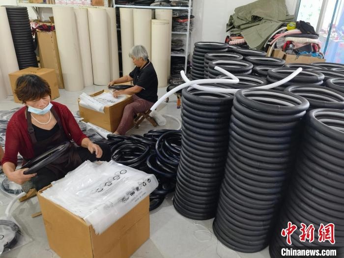 圖為村民在汽車飾品企業(yè)生產(chǎn)車間中工作?！巫雍?攝