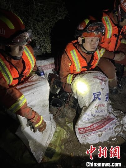 短暫修整期間，消防員脫掉鞋襪，用編織袋套住腿腳保暖?！￠Z旭輝 攝