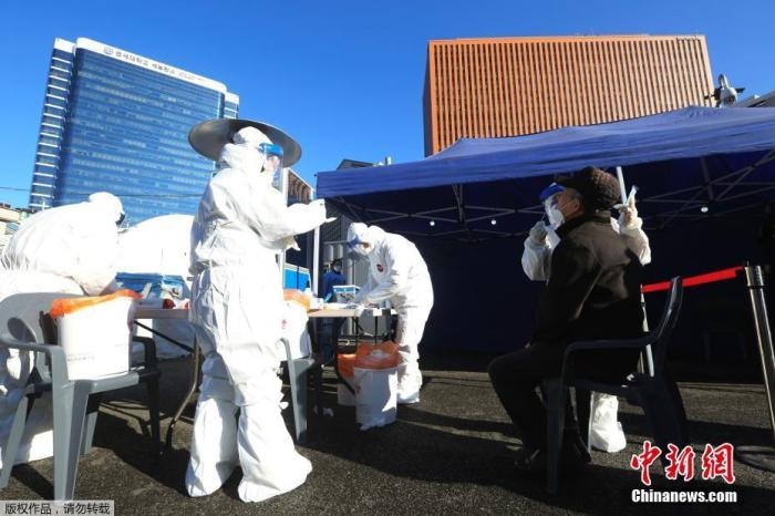 資料圖：韓國(guó)首爾，醫(yī)務(wù)人員對(duì)市民進(jìn)行新冠病毒檢測(cè)。