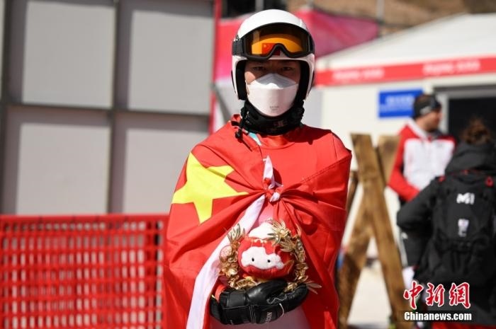 3月6日，中國選手梁景怡在賽后手捧吉祥物。當日，北京2022年冬殘奧會殘奧高山滑雪男子超級大回轉-站姿決賽在國家高山滑雪中心舉行，中國選手梁景怡奪得冠軍。 <a target='_blank' href='/'>中新社</a>記者 劉冉陽 攝 　