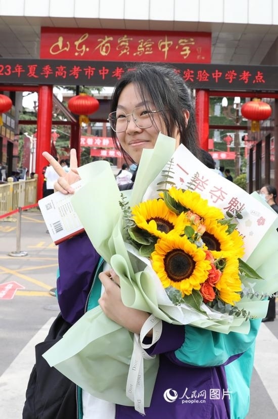 6月7日高考首日，山東67萬考生走進(jìn)考場，拼搏逐夢。在山東省實驗中學(xué)考點，考生進(jìn)考場前手捧向日葵花拍照留念，寓意“一舉奪魁”。人民網(wǎng)記者 劉祺攝