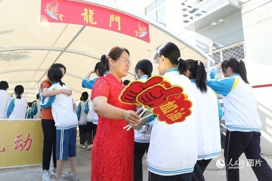 6月7日一早，雄安新區(qū)安新中學(xué)老師在給同學(xué)們加油鼓勁兒。人民網(wǎng) 李兆民攝