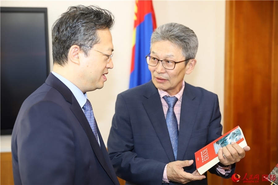 其米德策耶（右一）向李峙介紹翻譯成果。人民網(wǎng)記者 霍文攝