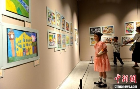 圖為家長(zhǎng)帶著孩子參觀展覽。呂明 攝