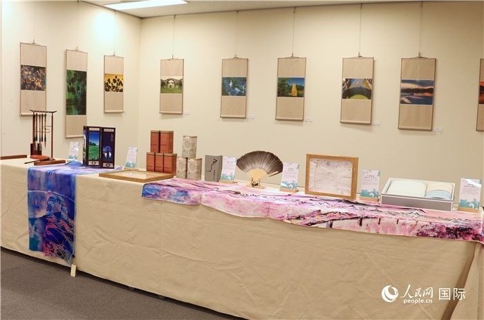 現(xiàn)場展出的馮學敏攝影作品與湖州市特色工藝品。（人民網(wǎng) 許可攝）