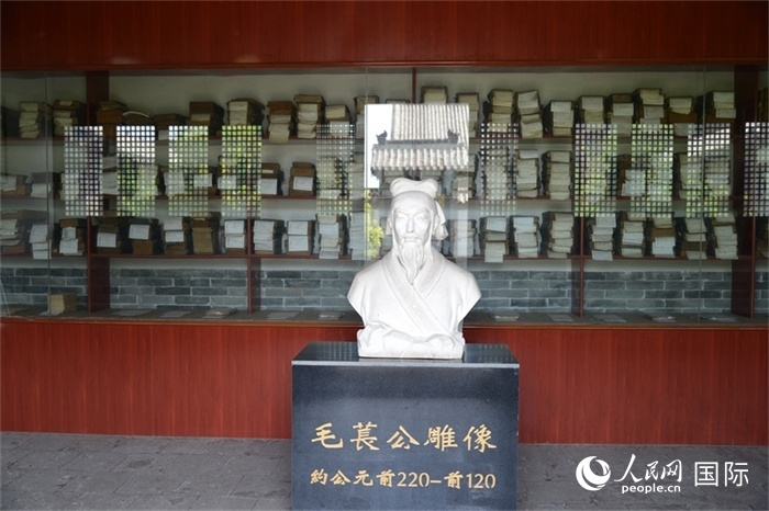 河間詩(shī)經(jīng)齋毛萇雕像。雕像后書(shū)櫥中陳列的是歷代各版本《詩(shī)經(jīng)》及譯本。 人民網(wǎng) 趙昭攝