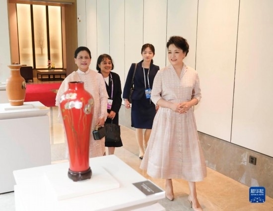 7月27日下午，國家主席習(xí)近平夫人彭麗媛在四川成都會見陪同印度尼西亞總統(tǒng)佐科來華出席第31屆世界大學(xué)生夏季運動會開幕式并訪華的總統(tǒng)夫人伊莉亞娜。這是彭麗媛和伊莉亞娜欣賞成都特色非遺工藝品。新華社記者 丁林 攝