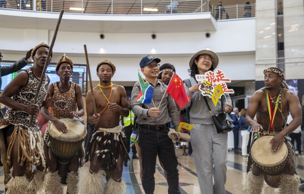 在南非約翰內(nèi)斯堡坦博國(guó)際機(jī)場(chǎng)，南非舞蹈演員歡迎中國(guó)試點(diǎn)恢復(fù)出境團(tuán)隊(duì)旅游后首批抵達(dá)南非的中國(guó)游客（2023年3月29日攝）。