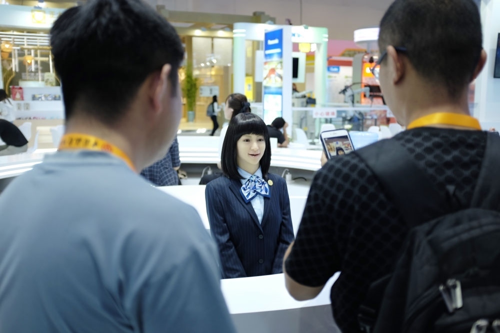 9月1日，媒體記者在國(guó)家會(huì)議中心與服務(wù)機(jī)器人互動(dòng)。新華社記者 劉夢(mèng)琪 攝