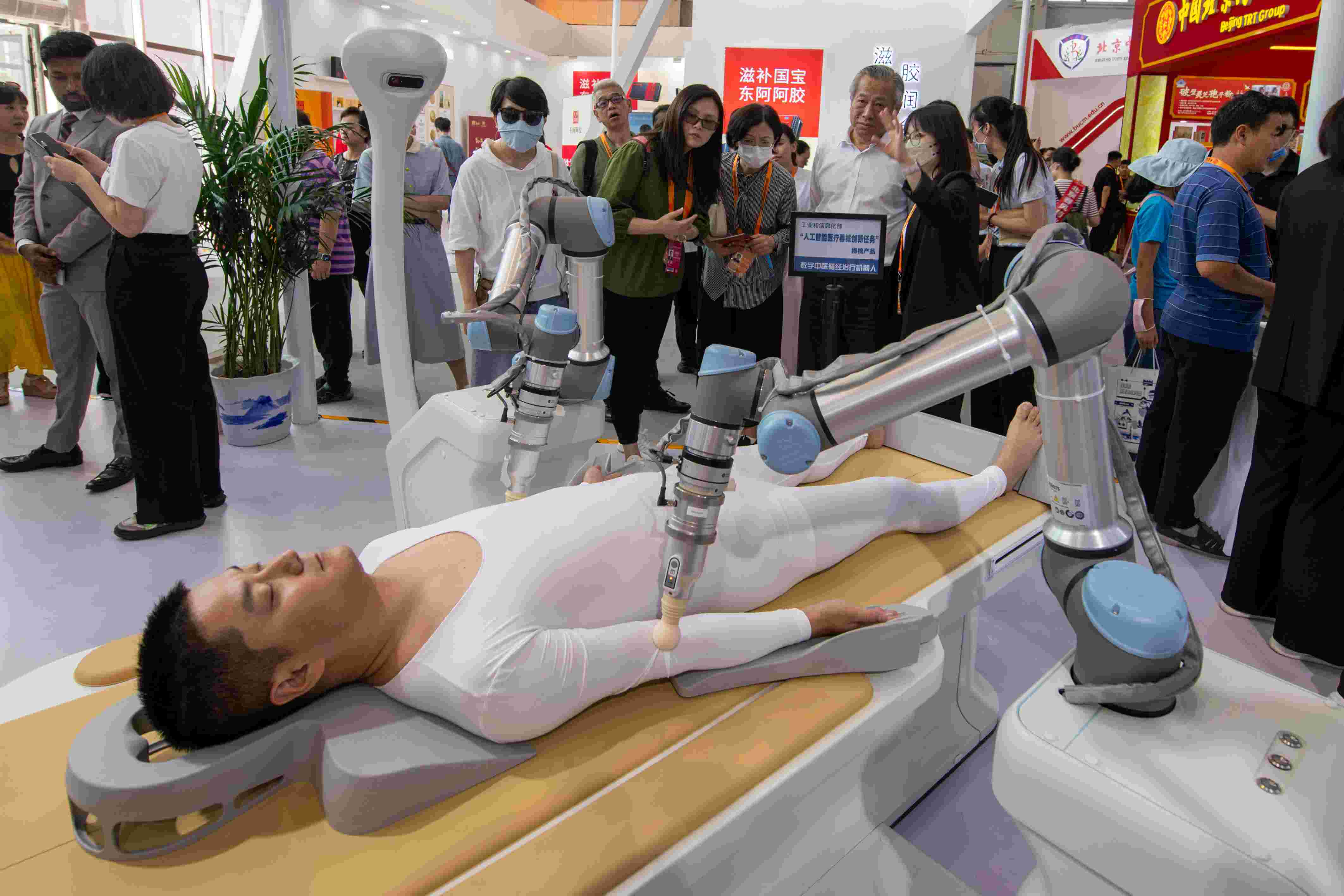 在位于首鋼園的健康衛(wèi)生服務(wù)展區(qū)，觀眾正在參觀數(shù)字中醫(yī)循經(jīng)治療機(jī)器人。人民網(wǎng)記者 翁奇羽攝