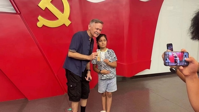 潘維廉和志愿講解員紀念合影。主辦方供圖