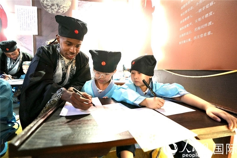 圖為選手與同學們一起寫書法。人民網(wǎng) 盧鵬宇攝