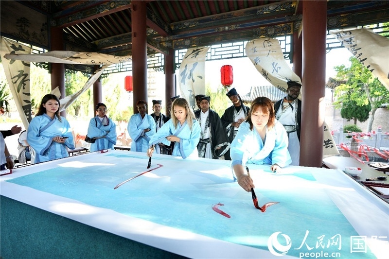 選手們提筆書寫“家園”二字。人民網(wǎng) 盧鵬宇攝