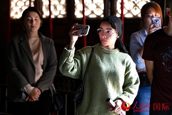 選手顏青（蘇丹）用手機記錄所見所感。人民網(wǎng) 盧鵬宇攝