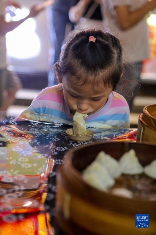 9月27日，小朋友在南翔小籠長(zhǎng)街宴上品嘗南翔小籠。