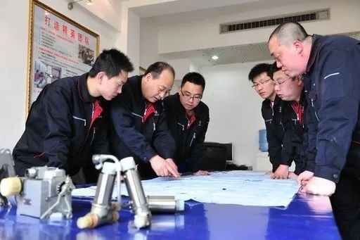 △李志強(qiáng)（左二）與班組成員在研究工作。