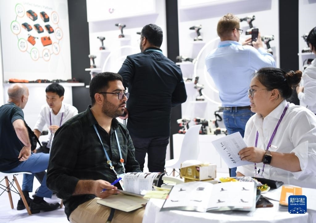 10月15日，在一家電動工具展臺，外國采購商在洽談業(yè)務。新華社記者 鄧華 攝