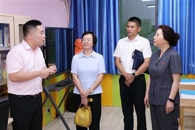 圖③：“小公民法律課堂”開(kāi)講前，全國(guó)人大代表殷其龍（右二）、重慶市人大代表李自玲（左二）聽(tīng)取楊家坪中學(xué)負(fù)責(zé)人關(guān)于未成年人思想教育工作情況的介紹。