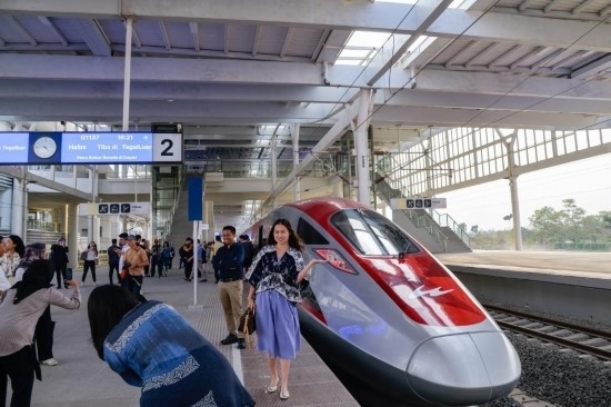 10月17日，在印度尼西亞萬隆德卡魯爾站，乘客在站臺上和雅萬高鐵高速動車組列車合影。新華社記者 徐欽 攝