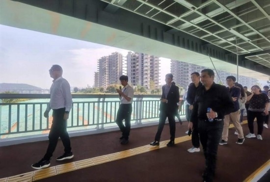 10月24日，2023“一帶一路”媒體合作論壇聯(lián)合采訪團團員走在清水塘大橋景觀通道上。本報記者 常雯宜攝