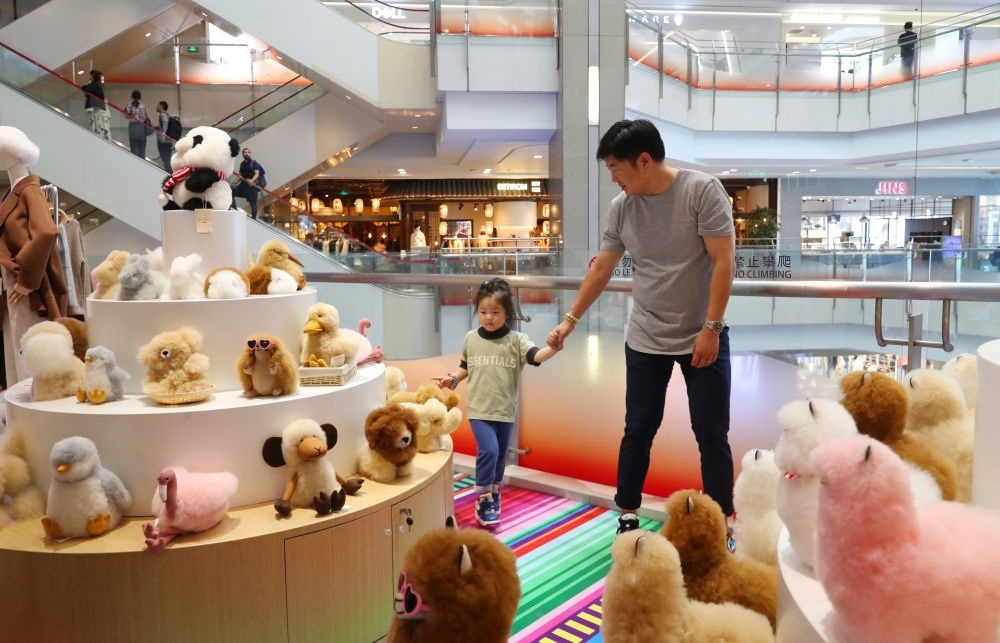 2023年11月2日，顧客在溫暖駝品牌專柜內(nèi)選購。連續(xù)六年參加進(jìn)博會的秘魯羊駝制品品牌溫暖駝在上海市中心商場開設(shè)了專柜。新華社記者 方喆 攝