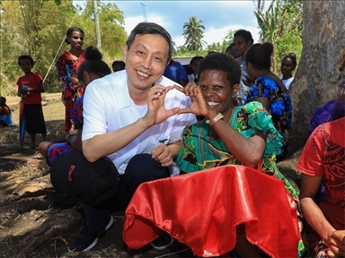 2023年12月18日，中國駐瓦努阿圖大使李名剛和前來觀看瓦努阿圖公路項目二期馬勒庫拉段移交儀式的當?shù)鼐用窈嫌?。人民網(wǎng) 賀吉攝