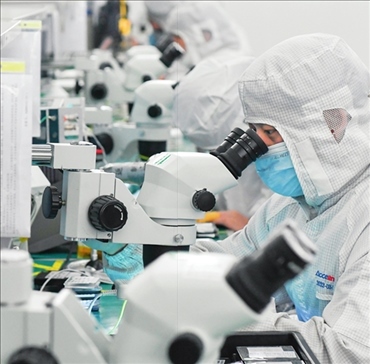 在位于武漢中國光谷的光電器件研發(fā)制造商——武漢光迅科技股份有限公司生產(chǎn)車間內(nèi)，技術(shù)人員在光模塊生產(chǎn)線作業(yè)（2023年4月11日攝）。程敏攝/本刊