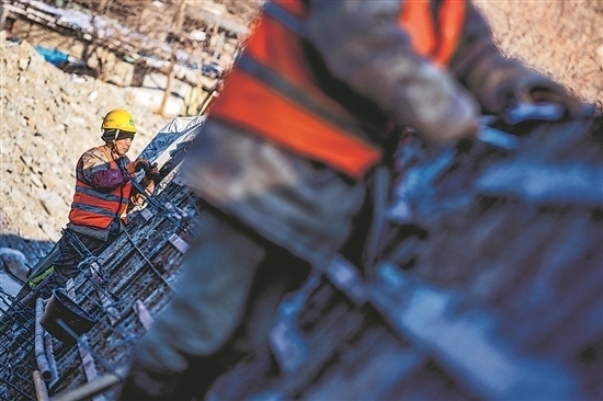 1月3日，房山區(qū)，工人正在雙泉河修筑堤壩。