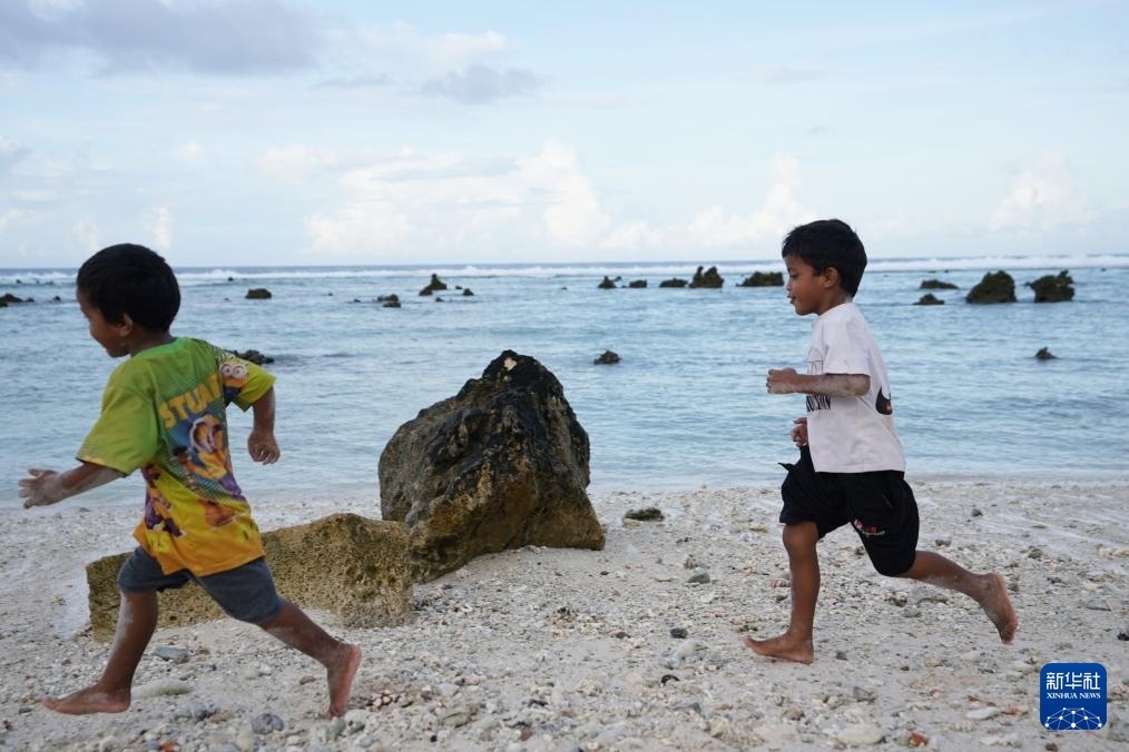 1月20日，兒童在瑙魯海邊嬉戲。新華社記者 王申 攝