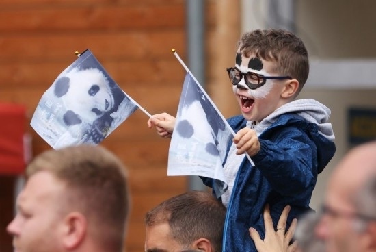  2023年7月26日，在法國圣艾尼昂市博瓦勒野生動物園外，一名兒童等待送別熊貓“圓夢”。新華社記者 高靜 攝