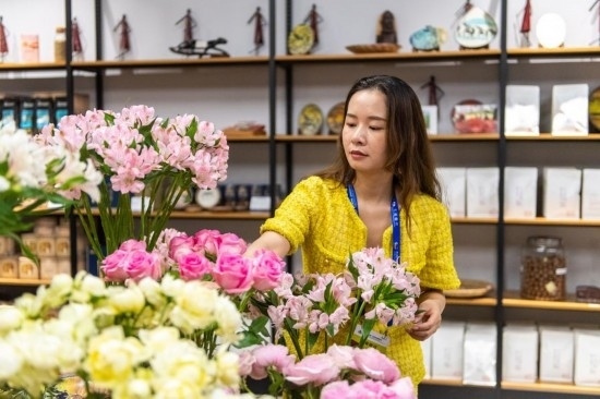 2023年7月1日，在位于湖南省長沙市的湖南高橋大市場，中非經(jīng)貿(mào)博覽會常設(shè)展館展區(qū)肯尼亞館工作人員在整理產(chǎn)自非洲的鮮花。新華社記者 陳思汗 攝