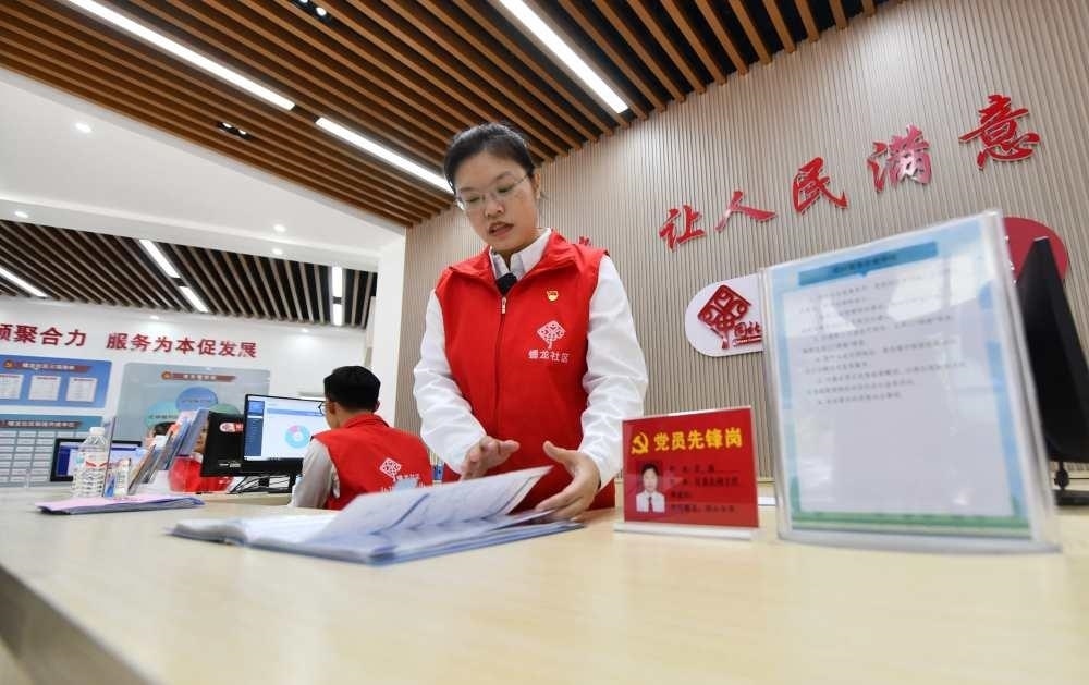 △2023年12月14日，廣西南寧市蟠龍社區(qū)，工作人員在為居民服務(wù)。