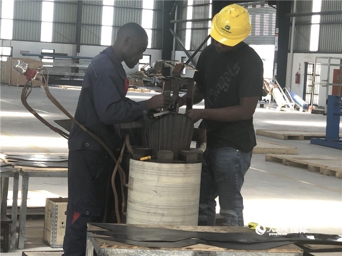 經(jīng)貿(mào)合作區(qū)廠房內(nèi)，當(dāng)?shù)毓と苏诰o張作業(yè)。人民網(wǎng)記者 黃培昭攝