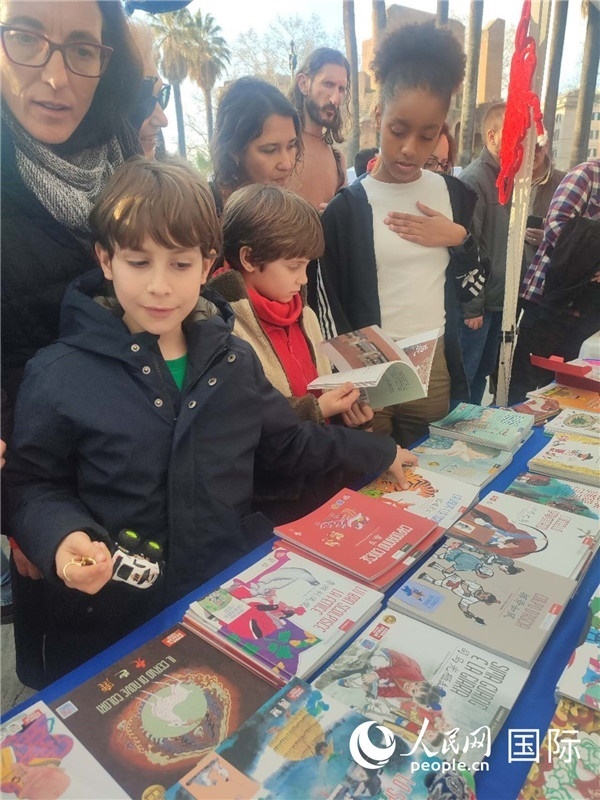 印刷精美的中國(guó)傳統(tǒng)文化叢書吸引了小游客的注意。人民網(wǎng)記者鄭彬攝