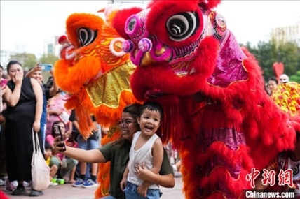 圖為舞獅表演吸引民眾合影。張興龍攝