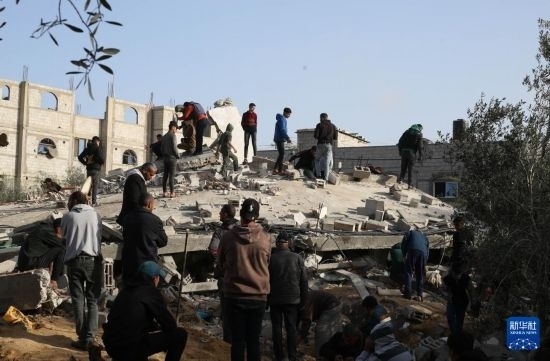  3月3日，在加沙地帶南部城市拉法，人們查看被以軍空襲破壞的建筑。新華社發(fā)（哈立德·奧馬爾攝）