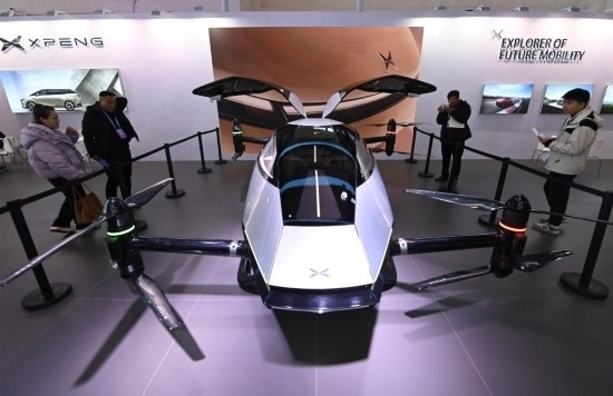 2023年12月1日，在鏈博會智能汽車鏈展區(qū)小鵬汽車展臺，參觀者觀看一臺智能飛行器。新華社記者蔡湘鑫攝