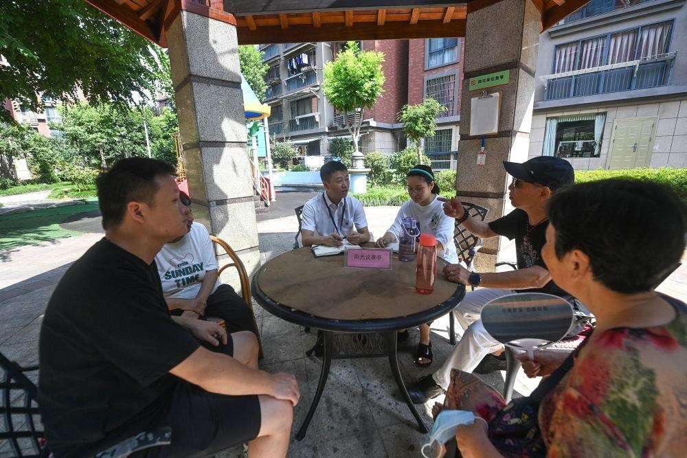 △2023年7月21日，在位于浙江杭州臨安區(qū)錦南街道水岸陽光小區(qū)的陽光議事廳，街道干部在聽取居民們反映的問題及意見。