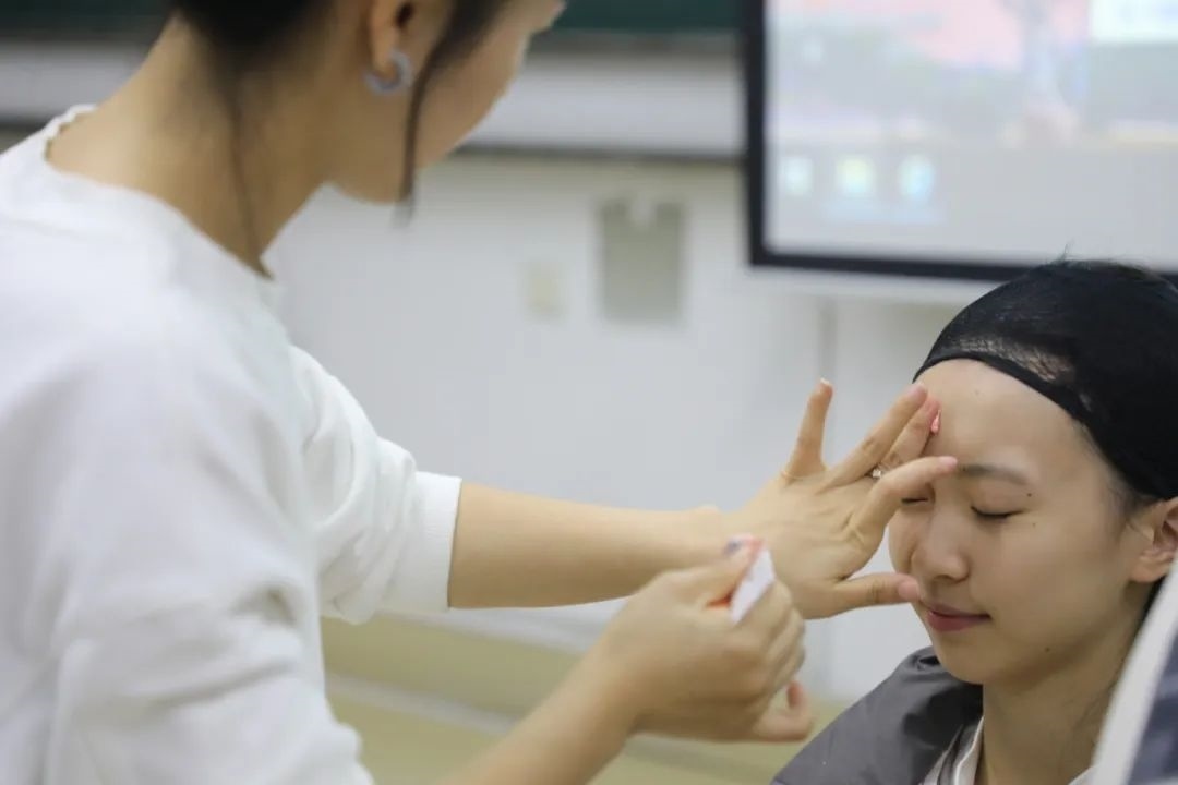 課堂上，一名學(xué)生在體驗(yàn)上戲妝。學(xué)校供圖