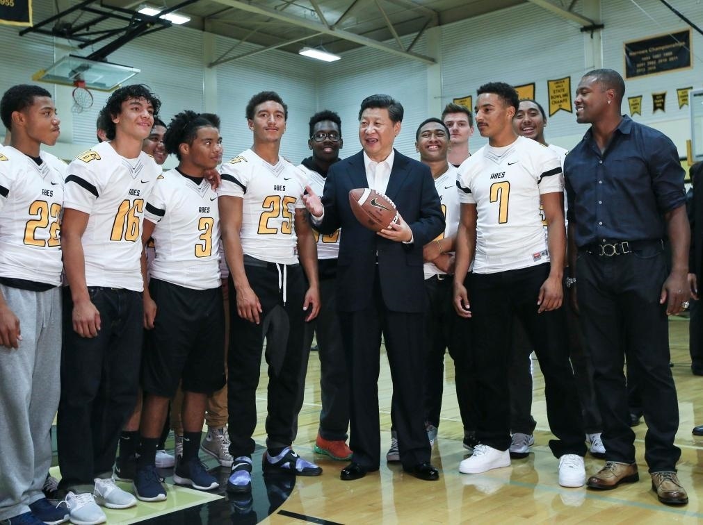 2015年9月23日，國家主席習(xí)近平參觀美國塔科馬市林肯中學(xué)。這是習(xí)近平在學(xué)校體育館，同上橄欖球訓(xùn)練課的學(xué)生們親切交談。新華社記者 蘭紅光 攝