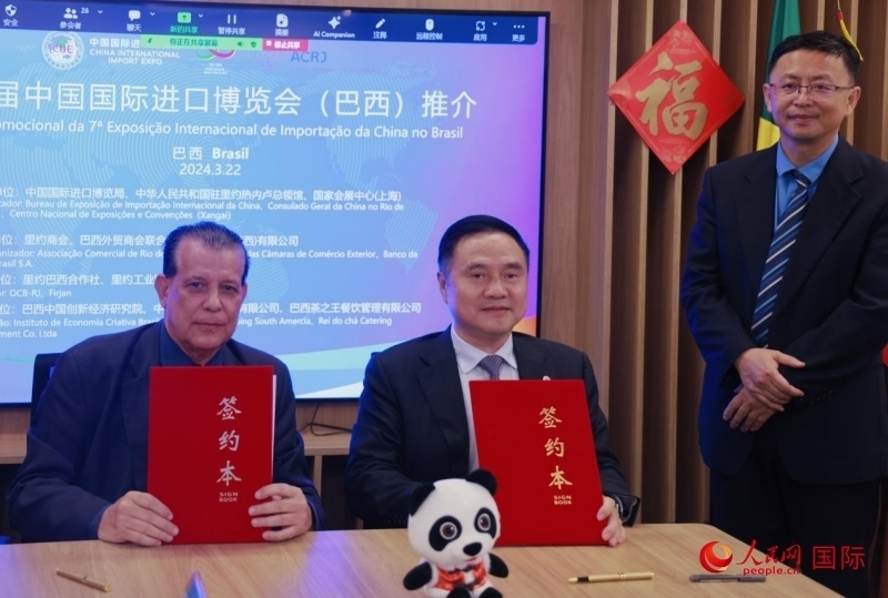 巴西外貿(mào)商會聯(lián)合會會長阿代爾·羅伯托（左）與中國國際進(jìn)口博覽局副局長吳政平（中）現(xiàn)場簽訂協(xié)議。人民網(wǎng)記者 宋亦然攝