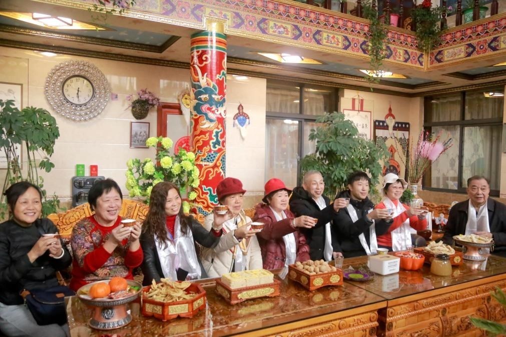 游客們?nèi)胱∶袼藓?，舉杯共飲酥油茶。新華社記者 邱星翔 攝