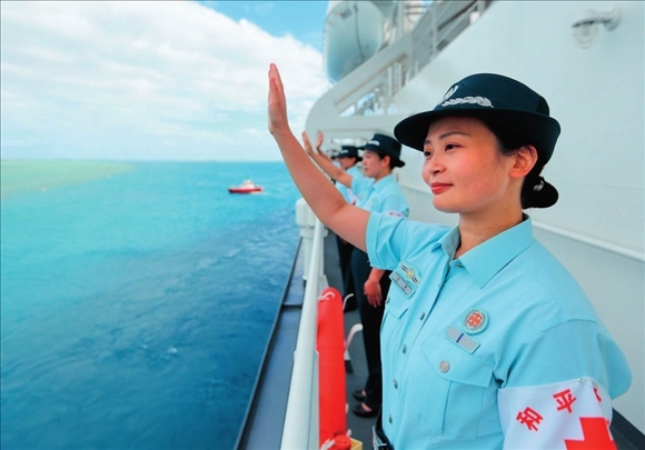 中國(guó)海軍“和平方舟”號(hào)醫(yī)院船結(jié)束訪問(wèn)湯加時(shí)，任務(wù)官兵中的文職人員向歡送人群揮手告別（2023年8月4日攝）。徐巍攝/本刊