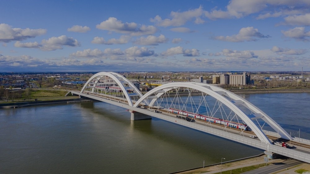 2024年3月12日，一列火車運(yùn)行在匈塞鐵路塞爾維亞境內(nèi)貝諾段諾維薩德多瑙河大橋上（無人機(jī)照片）。新華社發(fā)（任衛(wèi)云攝）