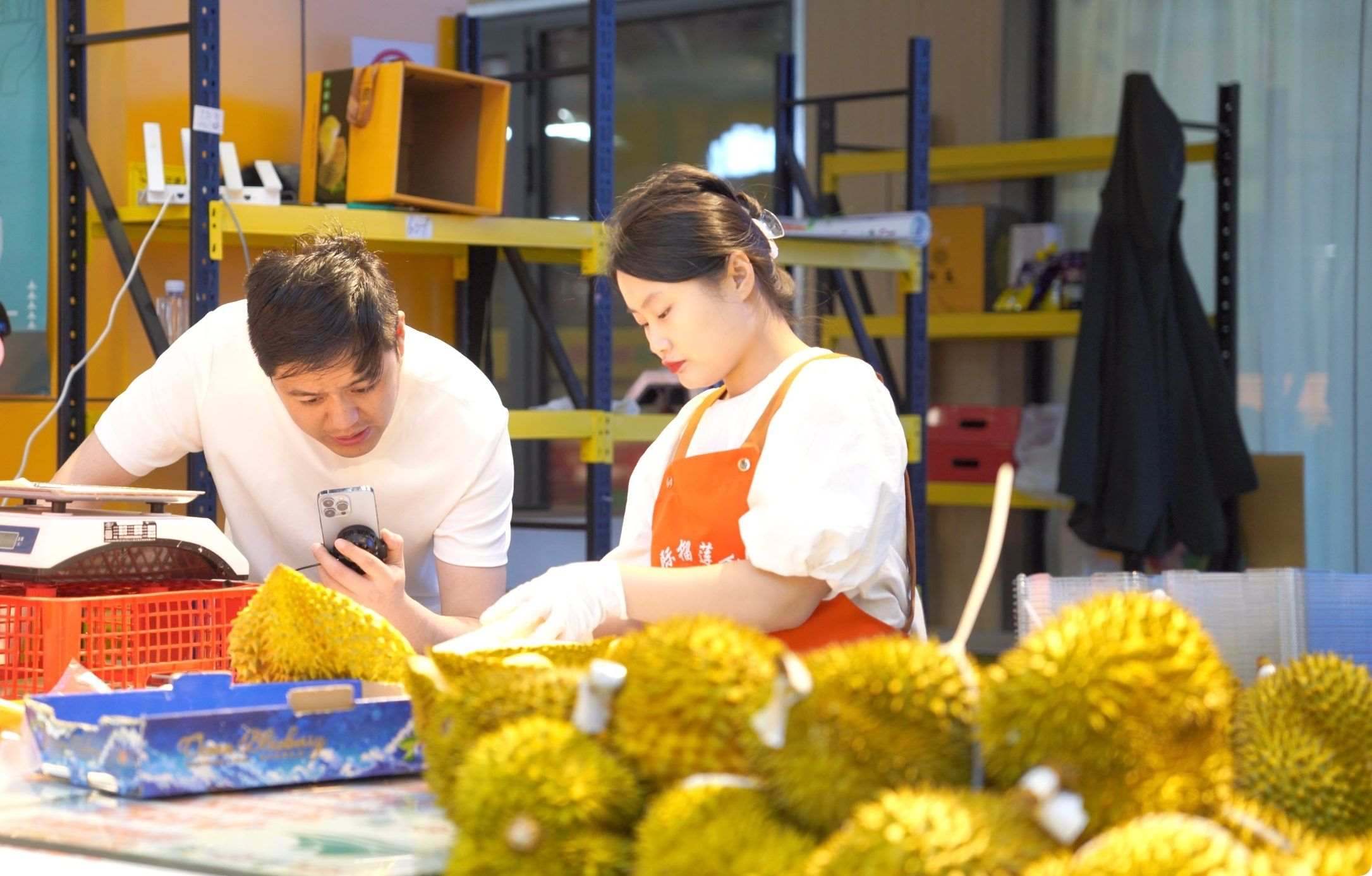 榴蓮商家正在通過(guò)手機(jī)直播銷(xiāo)售榴蓮。人民網(wǎng)記者申佳平 攝