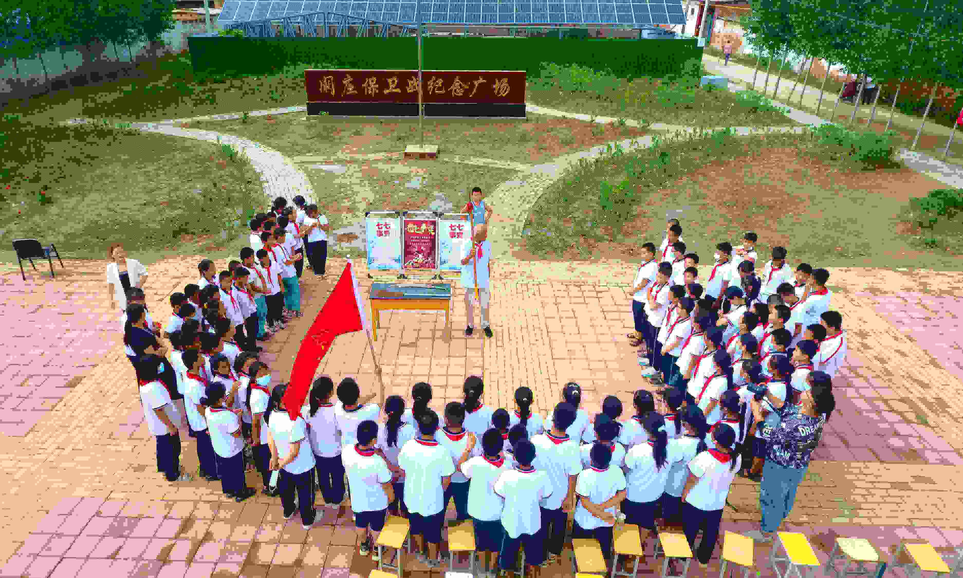 2022年7月6日，山東省聊城市，在茌平區(qū)菜屯鎮(zhèn)闞莊村的闞莊保衛(wèi)戰(zhàn)紀念廣場，闞莊保衛(wèi)戰(zhàn)親歷者王光木老人為小學生們講述抗戰(zhàn)故事，展示大刀、長矛。