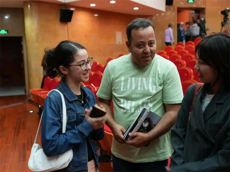 阿爾及利亞市民拉納·艾薩尼和她父親現(xiàn)場聆聽中阿交響樂演出 。蘇州交響樂團(tuán)供圖