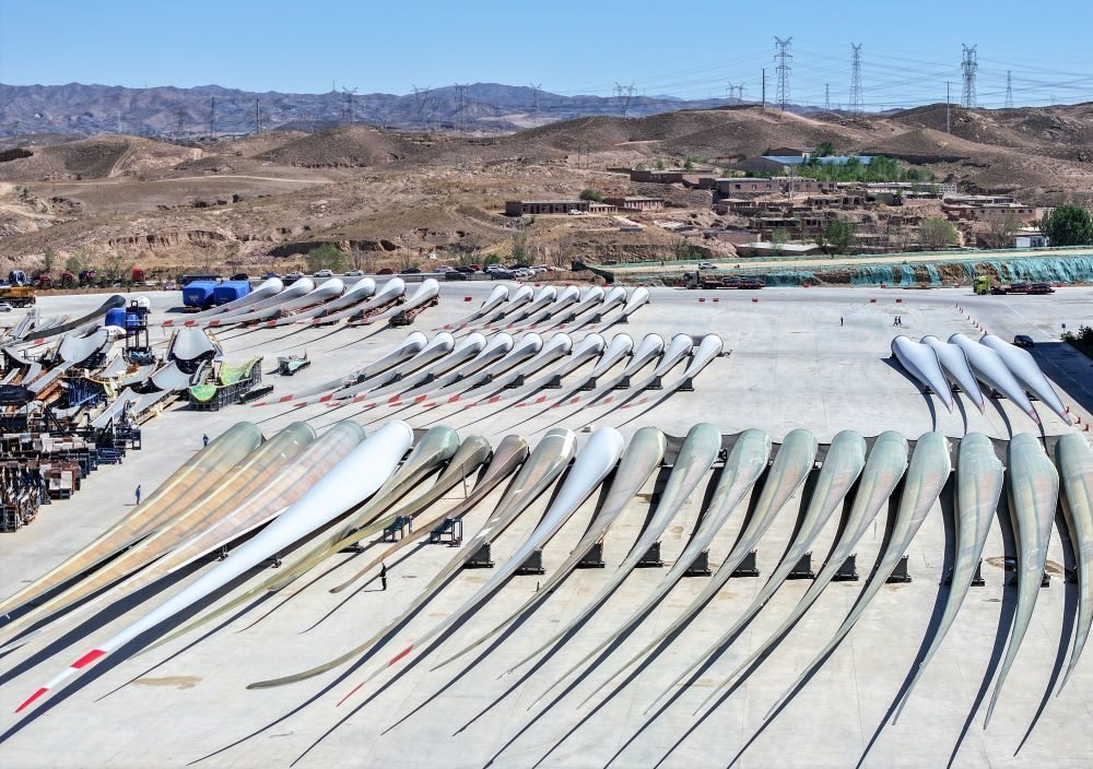 2024年5月11日拍攝的碼放在內蒙古包頭市石拐區(qū)一家風電設備制造企業(yè)廠區(qū)內的葉片（無人機照片）。新華社記者 連振 攝