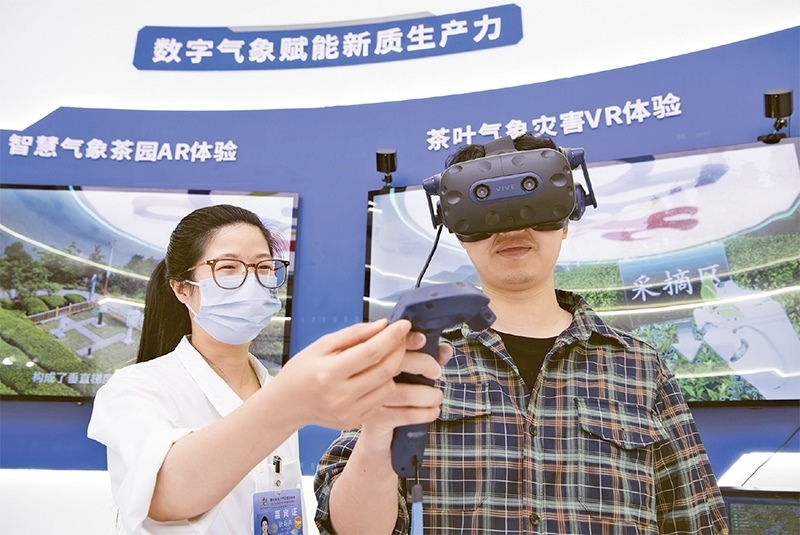 2024年5月23日，第七屆數(shù)字中國建設(shè)峰會現(xiàn)場體驗區(qū)在福州海峽國際會展中心向?qū)I(yè)觀眾開放。本次現(xiàn)場體驗區(qū)圍繞本屆峰會主題“釋放數(shù)據(jù)要素價值，發(fā)展新質(zhì)生產(chǎn)力”，設(shè)置“數(shù)字惠民”、“數(shù)字能力”、“數(shù)字基礎(chǔ)”、“數(shù)字生態(tài)”、“數(shù)字賦能”五大板塊。圖為一名觀眾（右）在數(shù)字氣象賦能新質(zhì)生產(chǎn)力展臺上進(jìn)行體驗。 新華社記者 魏培全/攝