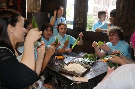 6月9日，美國(guó)青年代表在重慶永川松溉古鎮(zhèn)體驗(yàn)包粽子。新華社記者 周思宇 攝